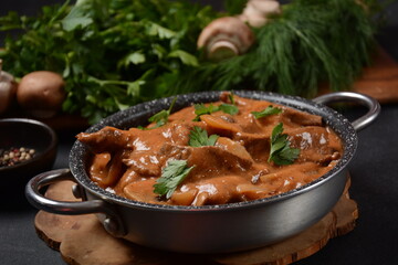 Traditional beef stroganoff with cremini and champignons in casserole