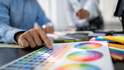 Freelance creative designer team creation project with color chart in meeting.