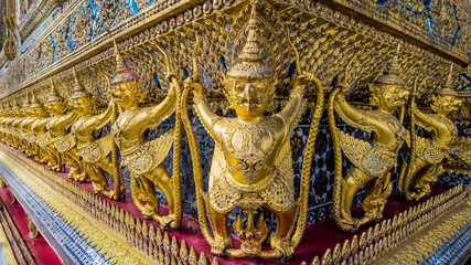 Golden garuda and naga statue, decoration on a wall of The Emerald Buddha temple, Wat Phra Kaew, Grand Palace, Bangkok, Thailand