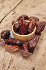 Dates fruit in ceramic plate on color paper background. healthy food concept. 