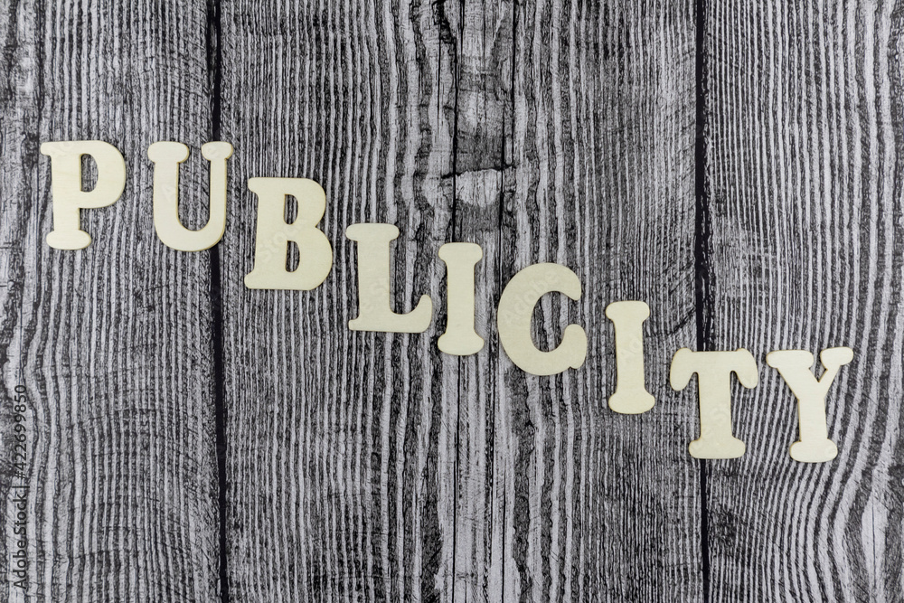 Fototapete publicity - concept with descending alphabet letters on cubes in a wavy line over old rustic wooden 