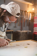 Male carpenter working on old wood in a retro vintage workshop.