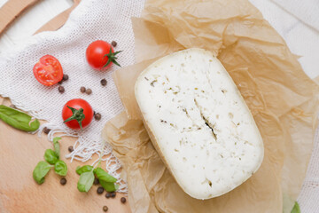 Medium hard cheese head parmesan on wooden board, with cheese parmesan with tomatoes on the table