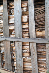 Chipped wood and sawn wood waste, stacked behind a partition of old planks. The concept of nature protection. Selective focus.