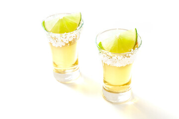 Tequila shots with salt and lime on white