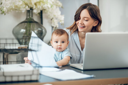 Smiling mom with cheerful child at laptop
