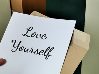 LOVE YOURSELF word written in letter from brown envelope.