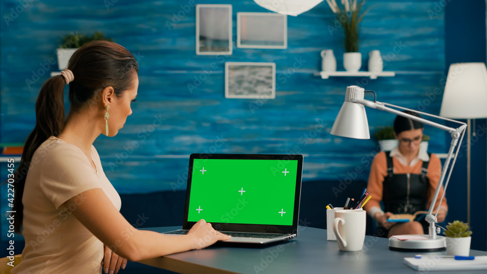 Poster freelancer using computer with mock up green screen chroma key for business company standing on desk
