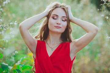 Young beautiful girl in a red dress in nature