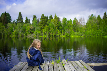 blonde girl portrait outdoor, pond shore in summer, selective focus
