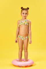 child girl in swimwear with inflatable rubber ring