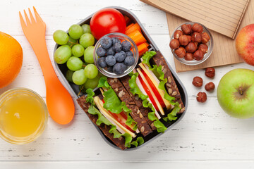Healthy school lunch box with sandwich and fresh vegetables