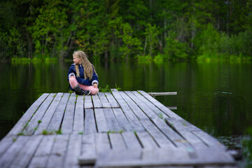 Fototapeta na wymiar blonde girl portrait outdoor, pond shore in summer, selective focus