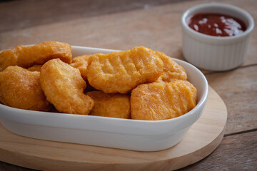 Fried crispy chicken nuggets and ketchup sauce in bowl