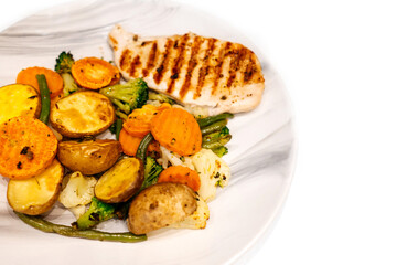 Grilled vegetables and chicken fillet on plate.