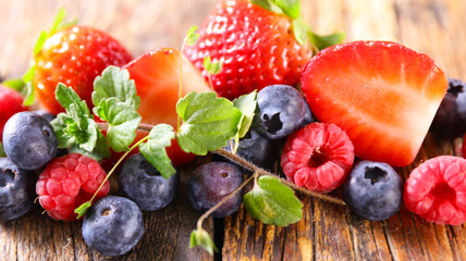 berries fruits and mint on wood background