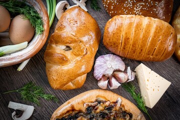 Puffs with spinach, eggs, green onions and cheese sprinkled with sesame seeds on wooden background, selective focus.