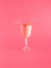 tropical pink juice overflowing from cristal glass on pink background. minimal abstract art. creative aesthetic idea