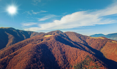 Aerial view of the colorful mountain range on an autumn sunny day. Beautiful natural landscape. Carpathians. Ukraine