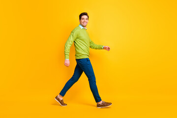 Fototapeta na wymiar Full length body size profile side view of attractive content cheerful guy executive manager walking isolated over bright yellow color background