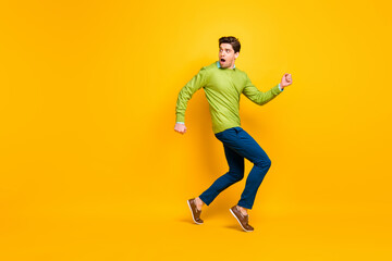 Fototapeta na wymiar Full length body size profile side view of nice funky guy walking sneaking escaping copy space isolated on vivid yellow color background