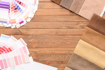 Frame made of color palettes and fabric samples on wooden background