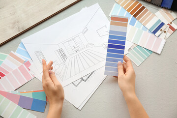 Female interior designer with color palettes and house plan in office