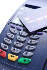 Obraz premium Payment terminal with credit card on white background, closeup