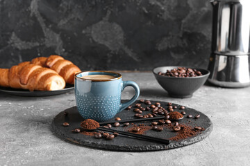 Cup of tasty hot coffee on grunge background