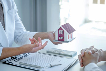 Hand of the real estate agent explains the business contract, rent, purchase, mortgage, a loan, or home insurance to the women buyer