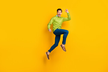 Fototapeta na wymiar Full length body size profile side view of attractive funky motivated cheerful guy jumping running isolated on bright yellow color background
