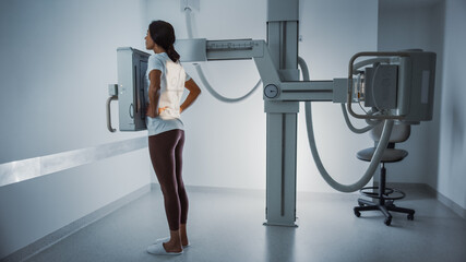 Hospital Radiology Room: Beautiful Multiethnic Woman Standing in the X-Ray Machine. Adult Female...