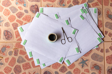 Double-sided adhesive, high angle Stick behind the white paper, and small scissors on top of all the paper placed on the patterned tile floor. Double-sided adhesive paper 