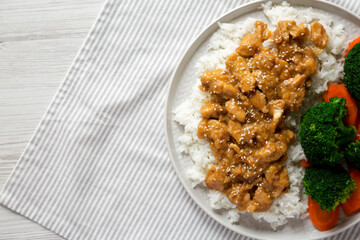 Homemade Orange Chicken with White Rice, Broccoli and Carrot on a plate, top view. Flat lay, overhead, from above. Space for text.
