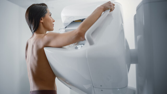 In the Hospital, Portrait Shot of Topless Multiethnic Female Patient Undergoing Mammography Screening Procedure. Healthy Adult Female Does Cancer Preventive Mammogram Scan in Radiology Room.