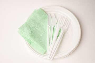 Disposable fork and knife on plate on a white background. Isolated. disposable tableware