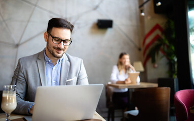 Obraz na płótnie Canvas Happy confident businessman working, using laptop in office