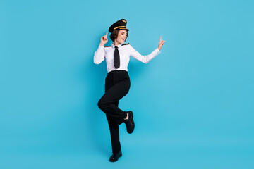 Full length photo of funky happy woman wear pilot uniform dance isolated on pastel blue color background