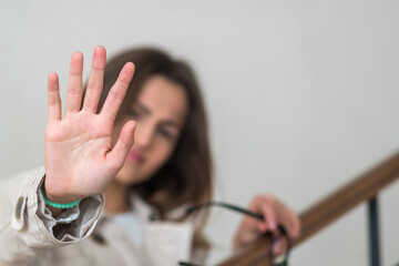 Young woman putting the palm of her hand forward communicating rejection, fear, or disgust
