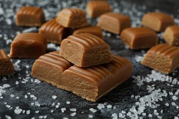 Salted caramel pieces on black smoky background, close up