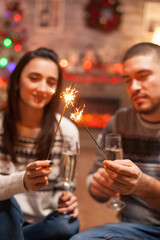 Glowing hand fireworks holded by young couple on christmas day.