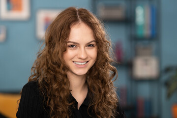 Fototapeta premium Portrait of young attractive smiling brunette teenage girl with curly hair.