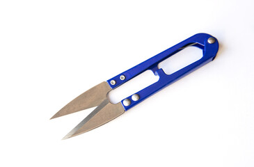 Blue scissors to cut the thread isolated on white background