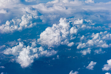 Cumuluswolken am blauen Himmel vom Flugzeugfenster aus gesehen