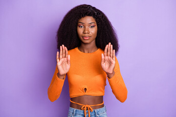 Portrait of attractive serious strict wavy-haired girl showing palms stop isolated over violet...