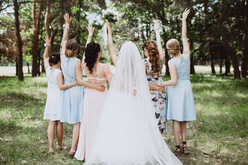 bride with bridesmaids turned their backs in the woods