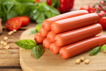 Fresh raw vegetarian sausages, basil and soybeans on wooden table, closeup
