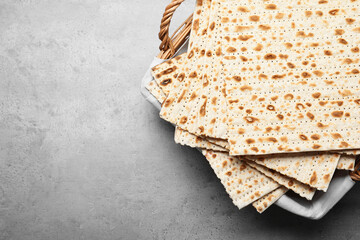 Traditional matzos in basket on light grey table, top view. Space for text