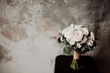 wedding bouquet of white roses and runculus on a gray background