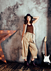 young pretty woman waiting alone in modern loft studio, fashion clothers wearing hat, lifestyle and...